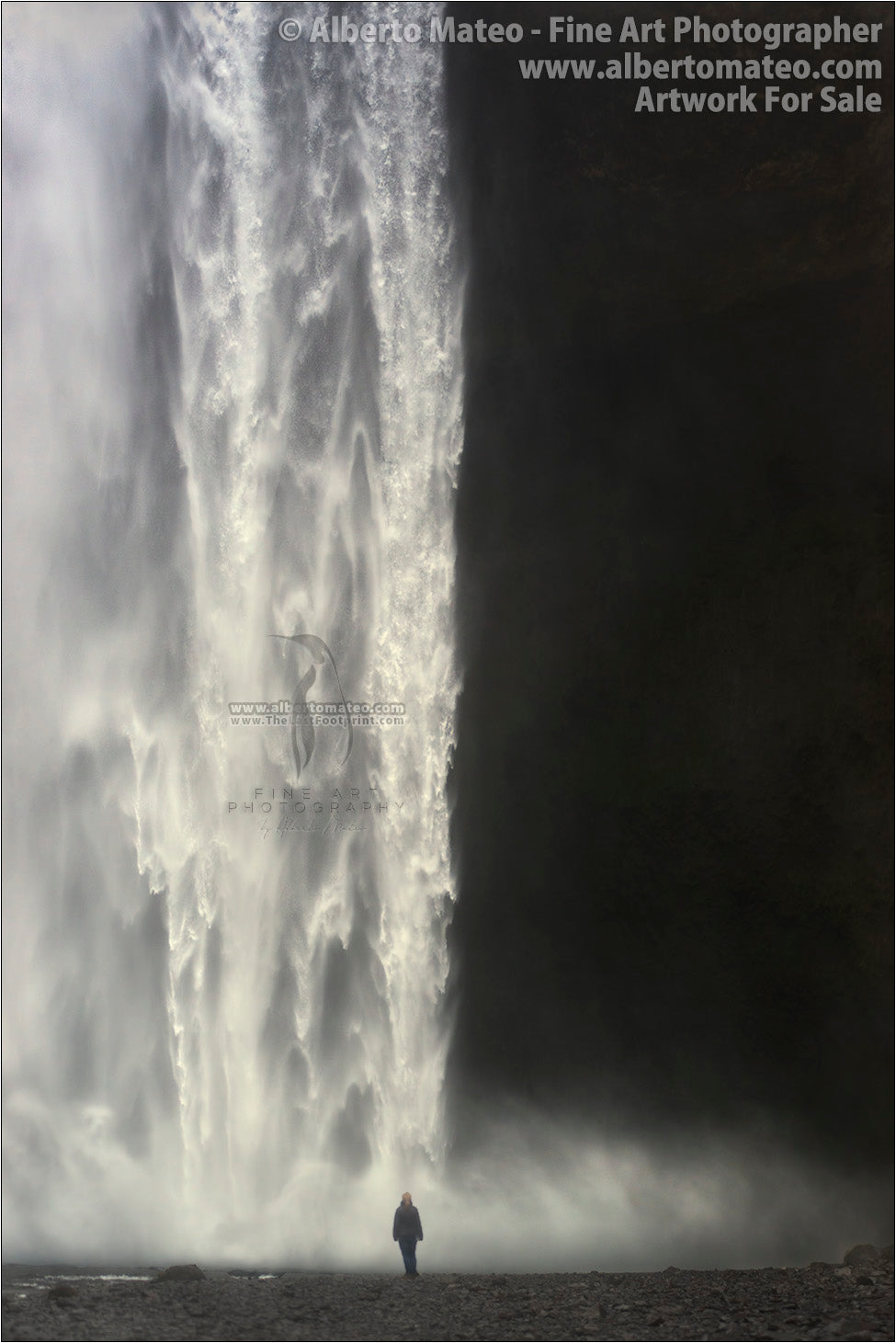 Woman under Skogafoss, Skogar, Iceland.