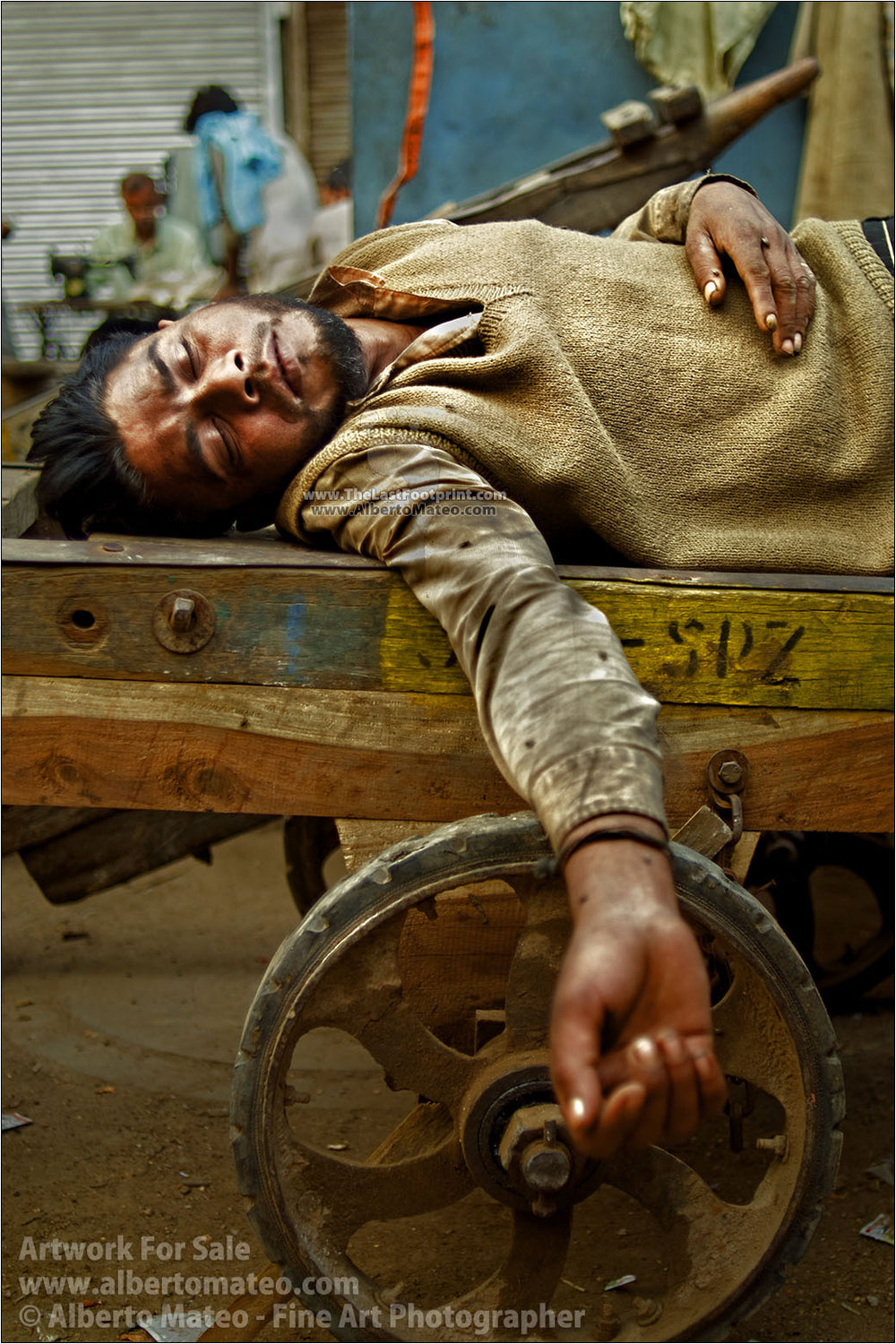 Carrier taking a nap on delivery charriot, Old Delhi. | By Alberto Mateo.