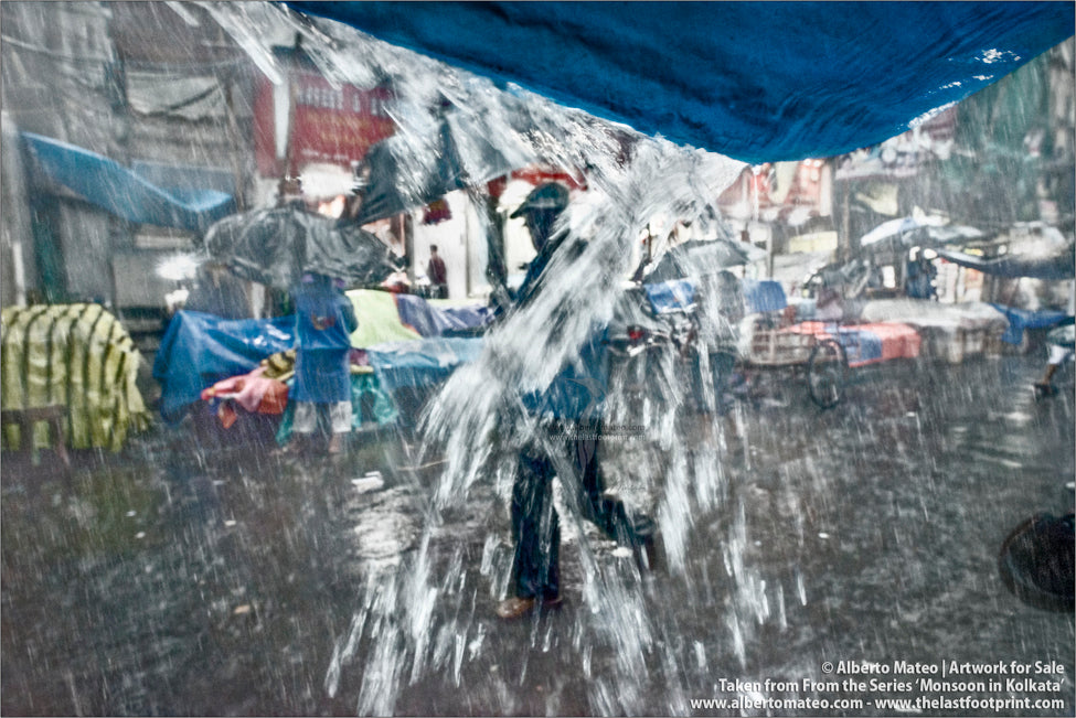 Man with umbrella under Heavy Downpour, Bara Bazar, Kolkata, Bengal, India.
