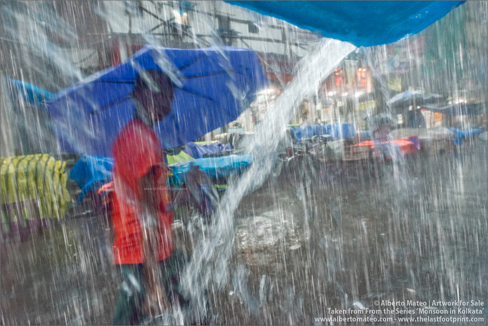Boy with umbrella under Heavy Downpour, Bara Bazar, Kolkata, Bengal, India.