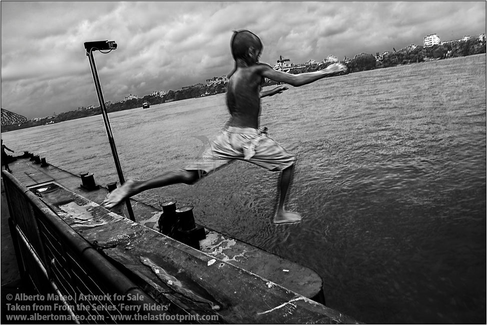 Boy jumping from docks, Kolkata, India.