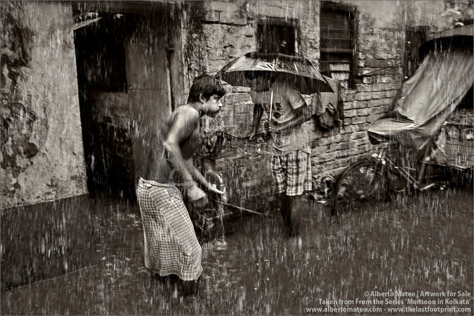 Men getting water from well under the rain, Kolkata, Bengal, India.