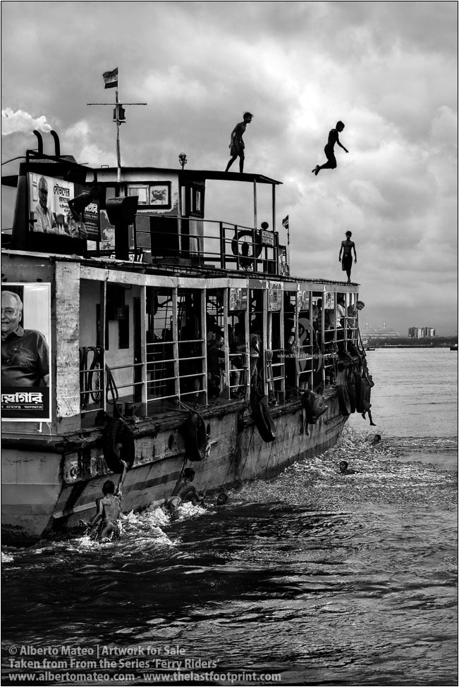Boys diving from the roof of a ship, Hooghly River, Kolkata, India.