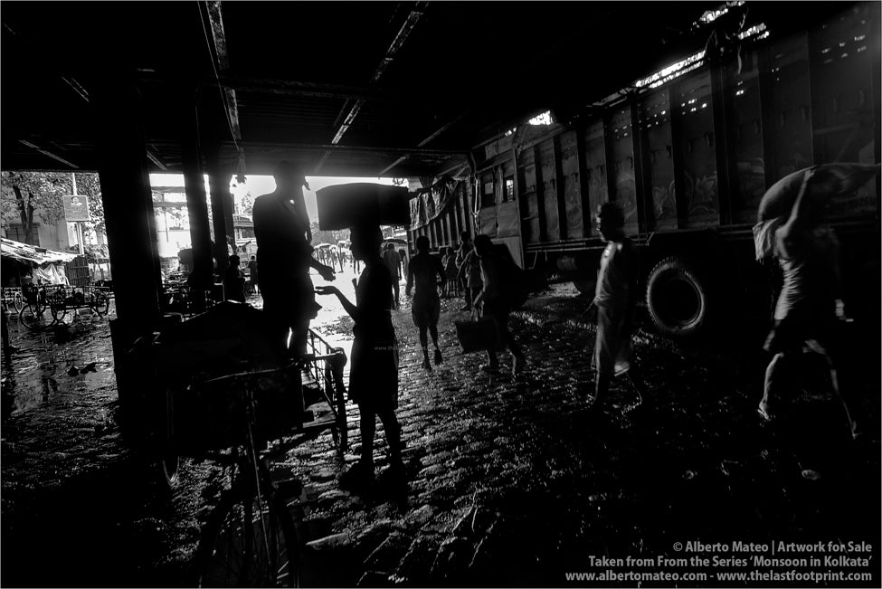 Porters under Howrah Bridge, Monsoon rain, Kolkata, Bengal, India.