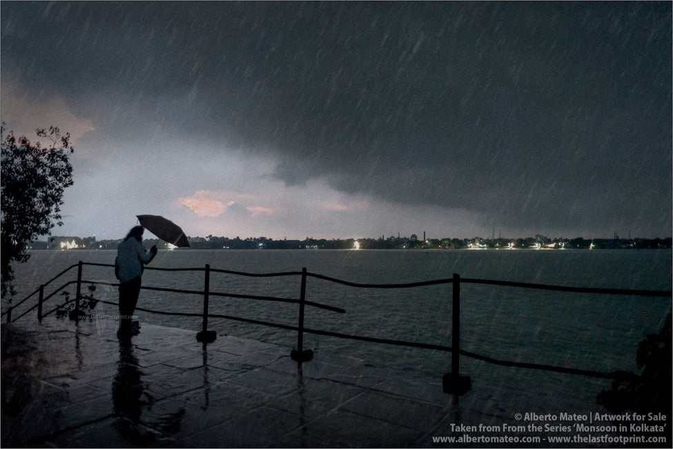 Man under umbrella next to Hooghly River, Kolkata, Bengal, India.