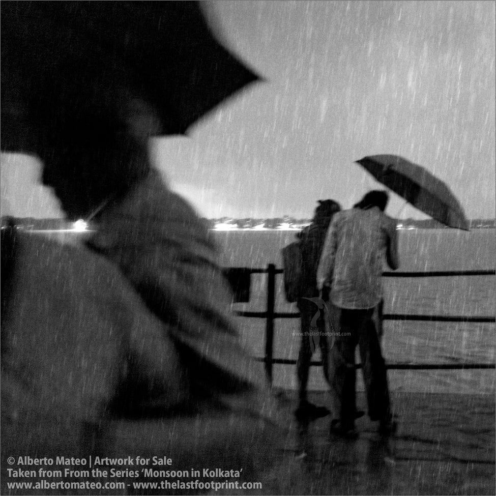 Two men chatting under umbrella next to Hooghly River. [DETAIL] Kolkata, Bengal, India.