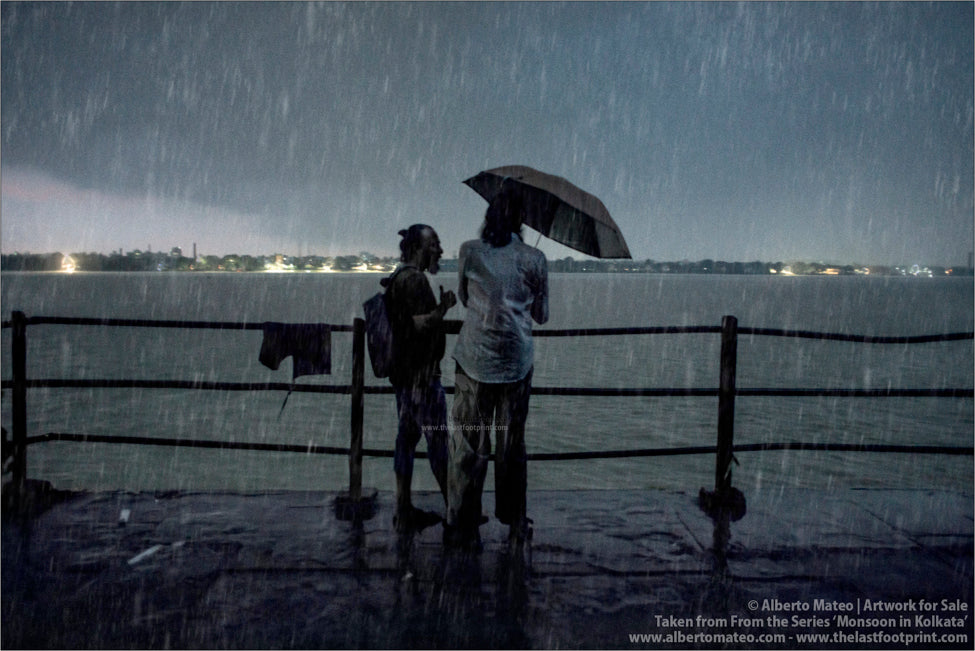 Two men chatting under umbrella, Hooghly River, Kolkata, Bengal, India.